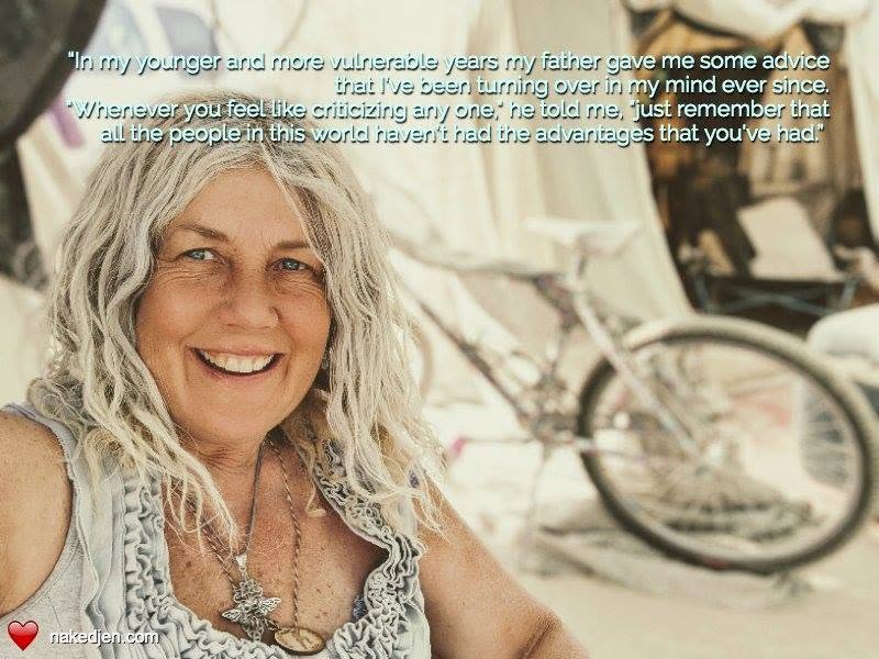 A smiling woman with long, wavy gray hair sits in front of a bicycle, reflecting on her father's advice about empathy and perspective.
